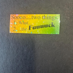 May include: A rectangular sticker with a gradient of yellow and green. The sticker has the text "Soooo... two things: 1. what... 2. the Fuuuuck" in black. The sticker has a holographic, glittery effect.