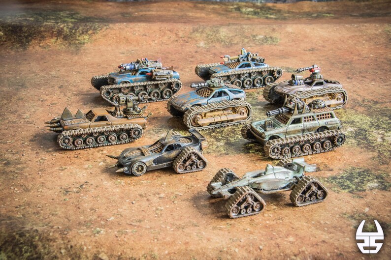 Puede incluir: Una colecci&oacute;n de siete veh&iacute;culos de combate en miniatura postapocal&iacute;pticos con orugas, acabados de pintura desgastados en tonos azul, marr&oacute;n, verde y gris, y armamento montado que incluye ca&ntilde;ones y p&uacute;as sobre diversos dise&ntilde;os de chasis.