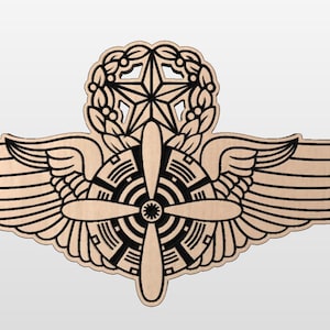 May include: A wooden aviator wings badge with a propeller and a star in a wreath. The wings are brown with black outlines. The propeller is black with a white center. The star is black with white outlines. The wreath is black with white outlines.