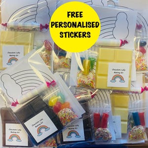 May include: A collection of clear plastic bags containing chocolate lolly making kits. Each kit includes chocolate, sweets, sprinkles, and a template. The kits are labelled "Chocolate Lolly Making Kit" with a rainbow design. A yellow circle reads "FREE PERSONALISED STICKERS."