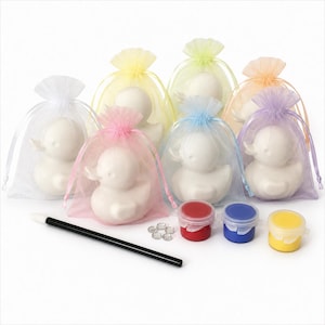 May include: A set of six white ceramic duck figurines, each individually packaged in a sheer organza drawstring bag in various pastel colours. The kit includes a black-handled paintbrush, three small paint pots in red, blue, and yellow, and five small clear decorative gems.