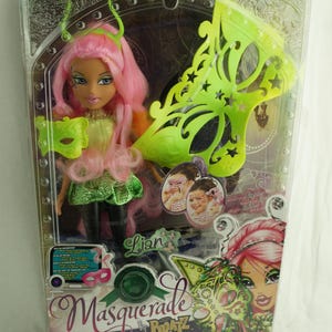 Puede incluir: Una muñeca Bratz de pelo rosa llamada Lian que lleva un disfraz de mariposa verde y dorada. La muñeca sostiene una máscara de mariposa verde. El embalaje dice "Masquerade by Bratz" y "The Girls with a Passion for Fashion".