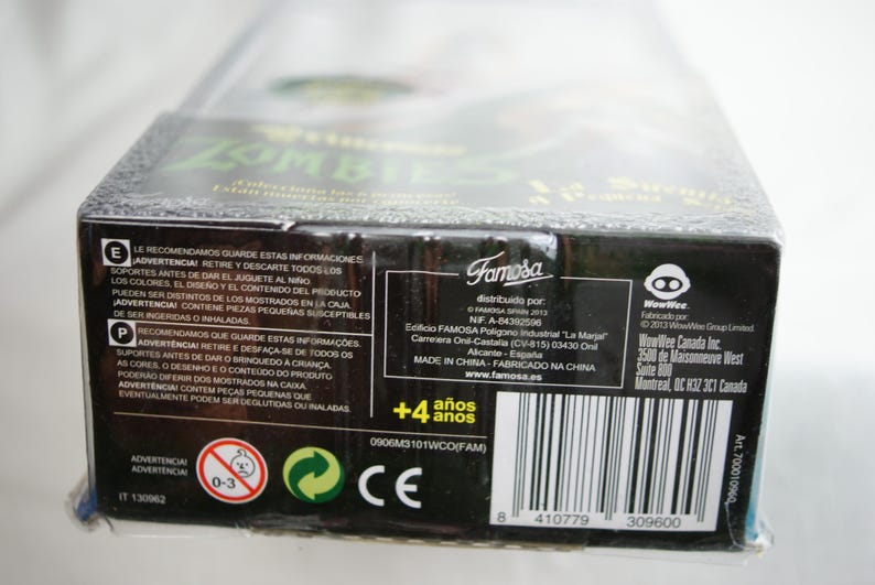 May include: A rectangular black cardboard toy packaging box featuring white text, safety warnings, and a barcode. The box includes the Famosa and WowWee logos, a 4+ age rating, and manufacturing information printed in multiple languages on the side panel.