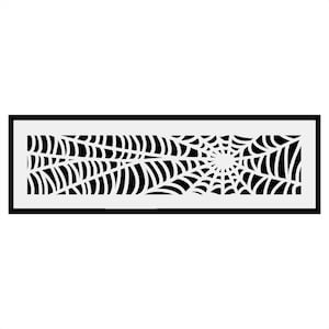 May include: Black and white spiderweb design in a rectangular frame. The design is a stylised spiderweb with a central point and radiating lines.