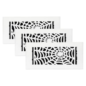 Puede incluir: Tres rejillas de ventilación rectangulares blancas con un diseño de telaraña negra. El patrón de telaraña está centrado y detallado, creando un elemento decorativo. Las rejillas están dispuestas en una presentación en capas.
