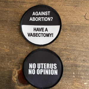 May include: Two round black and white patches with white text. The top patch says "Against Abortion? Have a Vasectomy!" The bottom patch says "No Uterus No Opinion".