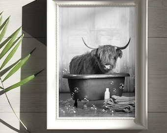Puede incluir: Impresión enmarcada en blanco y negro de una vaca de las Tierras Altas en una bañera. La imagen incluye burbujas, una toalla y una botella. El marco blanco tiene un borde de cuentas. El fondo muestra una puerta de madera.