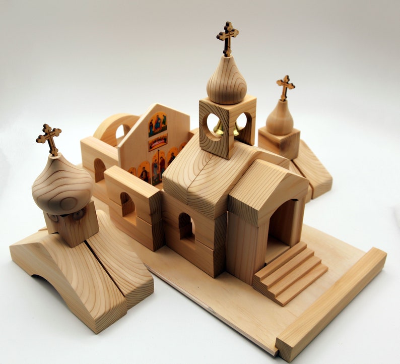 Pode incluir: Um conjunto de constru&ccedil;&atilde;o de igreja de madeira com v&aacute;rias pe&ccedil;as. O conjunto inclui uma estrutura principal da igreja, v&aacute;rios edif&iacute;cios menores e cruzes decorativas. A cor natural da madeira e o design simples criam uma apar&ecirc;ncia de brinquedo cl&aacute;ssico.