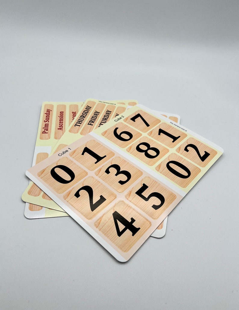 Op de afbeelding: Een set van twee houten dobbelstenen met een lichtbruin houtnerfpatroon. De dobbelstenen zijn gelabeld met de nummers 0-5 en 6-7, 8-1 en 0-2. De dobbelstenen zijn op elkaar gestapeld.