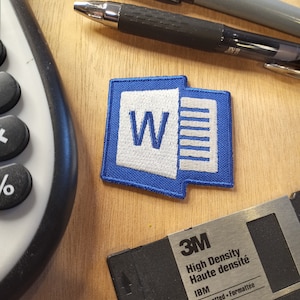 May include: A blue and white embroidered patch with the Microsoft Word logo. The logo is a white "W" inside a blue rectangle with a white vertical line on the right side.