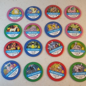 May include: A set of 14 round Pokemon trading cards featuring different Pokemon characters. Each card has a number, a Pokemon name, and a move with a damage value. The cards are colorful and feature illustrations of the Pokemon.