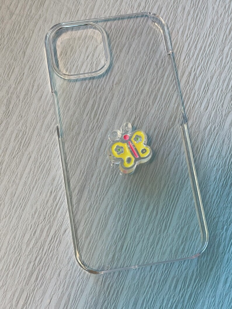 Op de afbeelding: Een transparante telefoonhoes met een geel vlinderontwerp. De vlinder heeft rode en groene accenten.