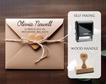 May include: A self-inking return address stamp with a wood handle. The stamp is black and has the text "tredat" on it. The text on the stamp reads "Olivia Newell, 14 Breck Ave #B, Brighton, MA, 02135".