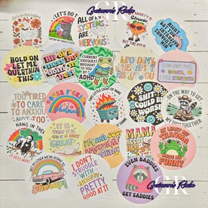 May include: A collection of circular stickers featuring various colorful illustrations and humorous text, including phrases like All of My Systems Are Nervous, I Told My Therapist About You, and Shit Could Be Worse, displayed in a grid-like arrangement.