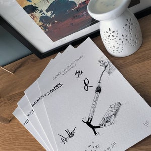 Puede incluir: Una pila de tarjetas blancas con dibujos de tinta negra de una figura de palo sosteniendo una cerilla. El texto "Carry Your Matches" está escrito en la tarjeta superior. La tarjeta inferior está numerada "15 de 222".