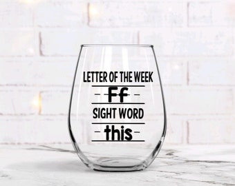 May include: A clear glass wine glass with the text "Letter of the Week - Ff - Sight Word - this" printed on it.