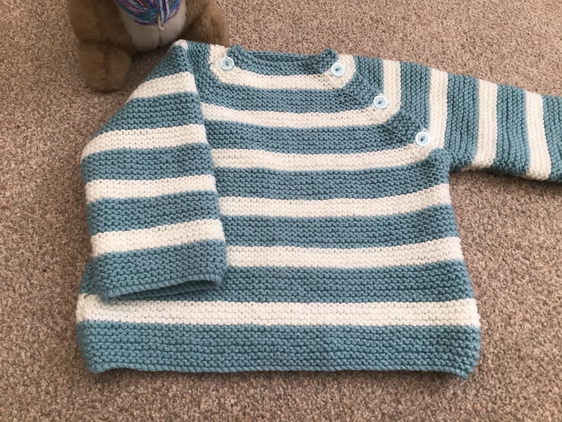 Baby\u2019s hand knitted Breton style jumper in pale blue and white 912 months approx .