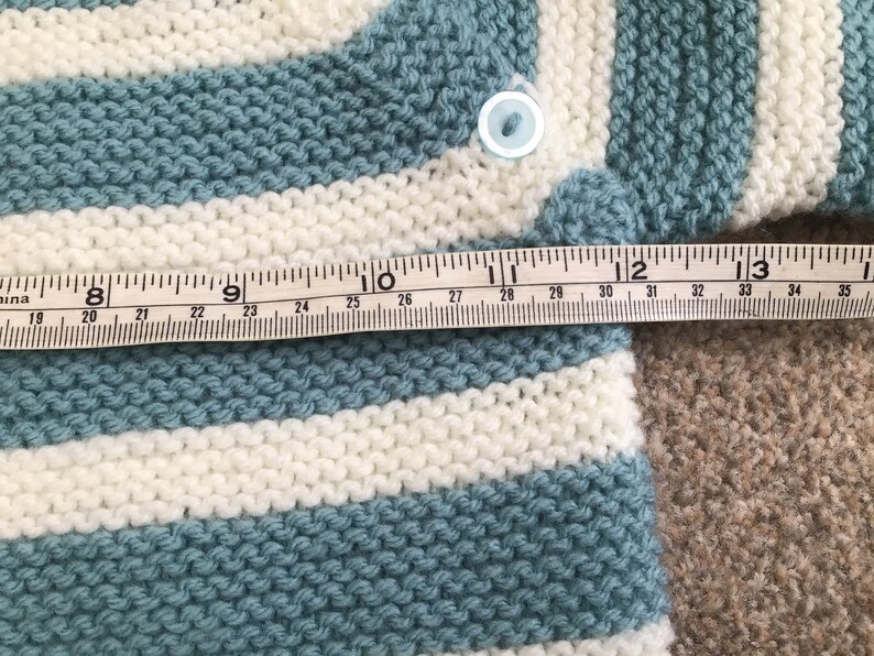 Baby\u2019s hand knitted Breton style jumper in pale blue and white 912 months approx .