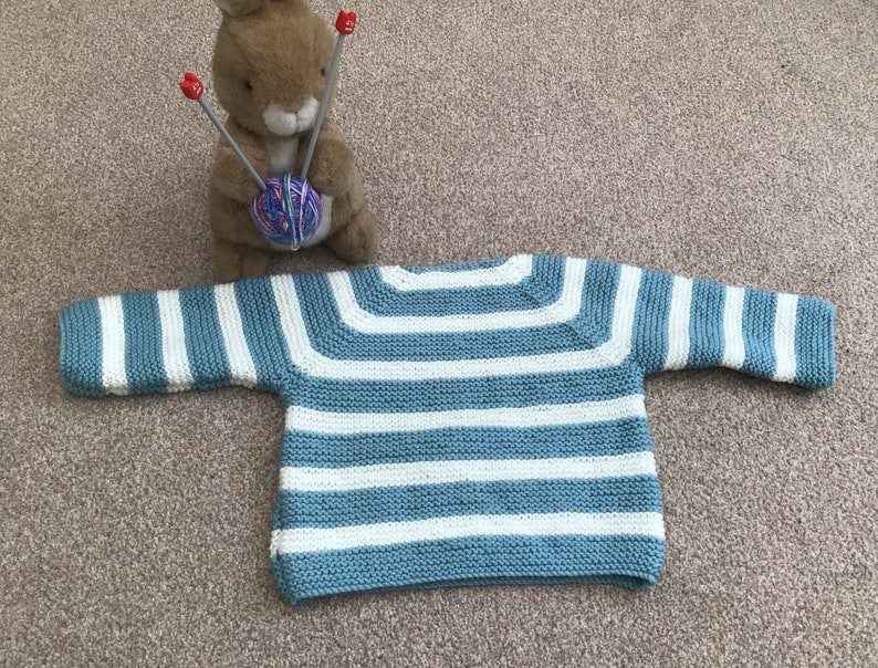 Baby\u2019s hand knitted Breton style jumper in pale blue and white 912 months approx .