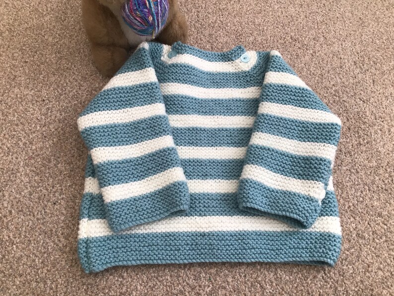 Baby\u2019s hand knitted Breton style jumper in pale blue and white 912 months approx .