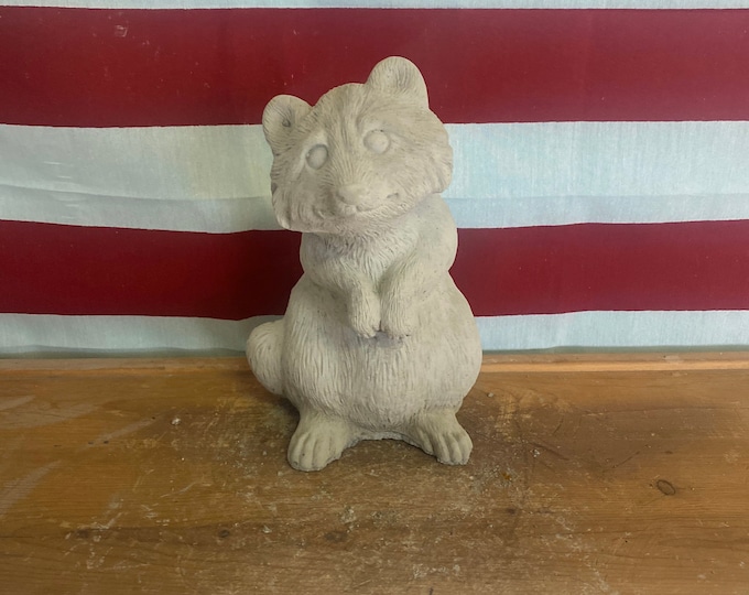 Standing raccoon concrete statue