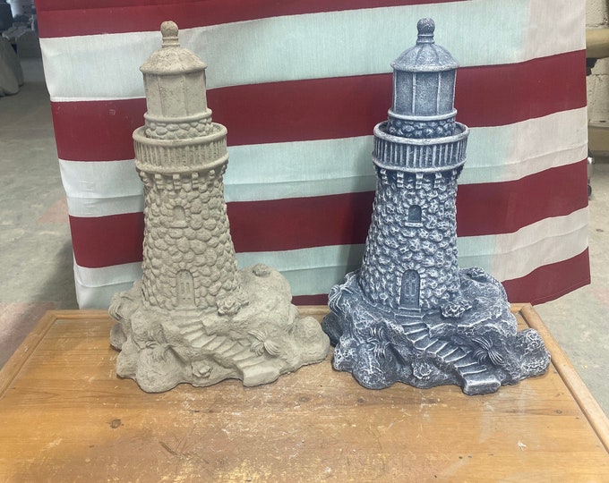 Lighthouse on rocks concrete statue