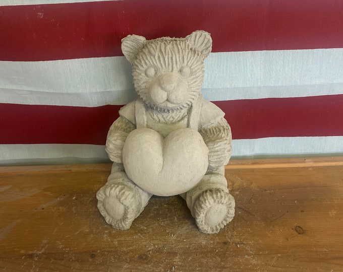Bear holding heart concrete statue