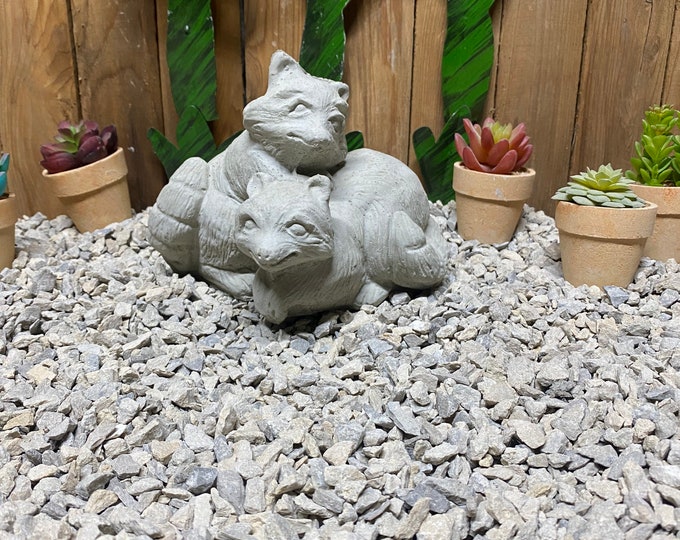 Playing raccoons concrete statue