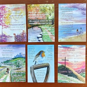 Könnte beinhalten: Eine Sammlung von Aquarelldrucken mit inspirierenden Zitaten und Bibelversen. Jeder Druck zeigt eine einzigartige Landschafts- oder Naturszene, darunter ein Baum, Berge und ein Vogel. Die rechteckigen Drucke variieren in der Farbe, mit Text in handschriftlichem Stil.