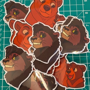 May include: A set of five stickers featuring cartoon animal faces. The stickers are printed on white paper with a glossy finish. The animals include a brown bear, a brown lion, and a red bear.