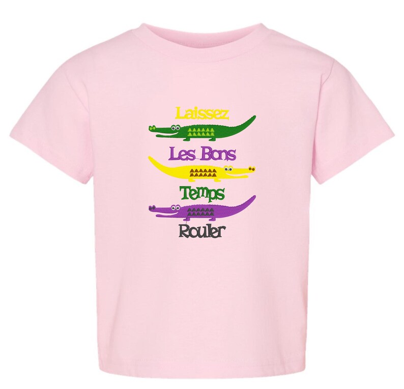 Puede incluir: Camiseta rosa con un gr&aacute;fico de cuatro caimanes con el texto "Laissez Les Bons Temps Rouler" impreso en ella.