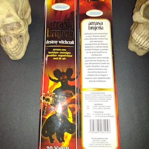 May include: A pack of 20 incense sticks with a red, orange, and yellow background. The packaging features a black cat, a spider, and a demon with a red and yellow background. The text on the packaging reads "arrasa brujeria destroy witchcraft" and "20 Varitas Incense stick".