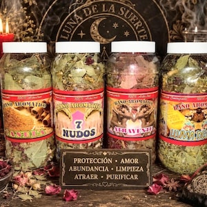 Pode incluir: Quatro frascos de plástico transparente com ervas secas e misturas botânicas, cada um com etiquetas "BAÑO AROMATICO" e nomes como "CANELA," "7 NUDOS," "ATRAYENTE," "LLUVIA DE ORO," e uma placa "PROTECCIÓN • AMOR • ABUNDANCIA • LIMPIEZA • ATRAER • PURIFICAR."