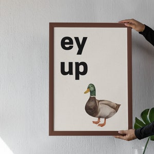 Puede incluir: Una impresión enmarcada con el texto "ey up" y una ilustración de acuarela de un pato.