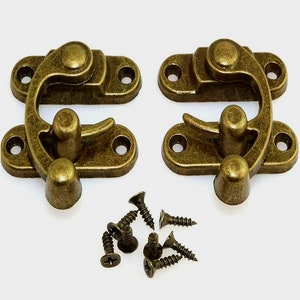 May include: Two antique gold-toned metal clasps with a curved latch and four screws.