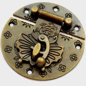 May include: Antique brass butterfly latch with a rose design. The latch is made of two pieces that fit together. It has a decorative floral pattern around the edge.