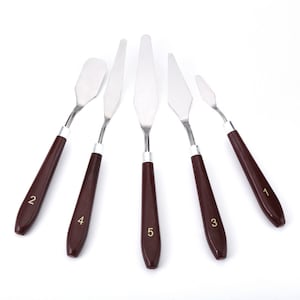 May include: Set of five painting palette knives with brown wooden handles. The knives are numbered 1 through 5.