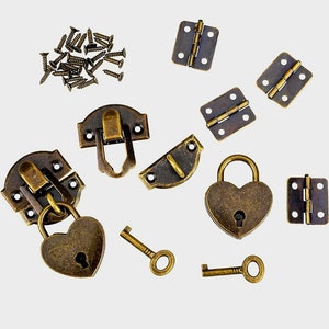 May include: A set of antique brass hardware for crafting projects, including two heart-shaped locks with keys, two latch clasps, four hinges, and a pile of screws.