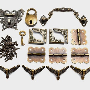 May include: A set of antique brass hardware for crafting projects, including hinges, corner brackets, a butterfly latch, a padlock, a key, a handle, and screws.