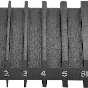 May include: A black metal gauge with six slots, numbered 1 through 5 and 6mm. The gauge is used to measure the size of rings.