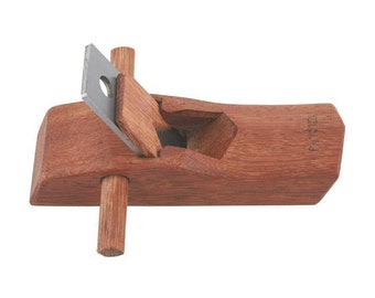 May include: A small wooden hand plane with a metal blade. The plane is made of reddish brown wood and has a handle on each side. The blade is partially visible and has a small hole in the center.