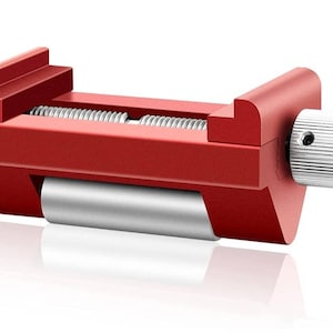 May include: A red metal clamp with a silver knob and a silver roller. The clamp is used to hold objects in place.