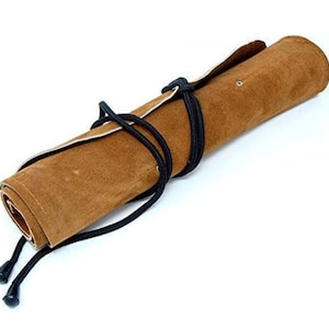May include: A brown leather roll with a black drawstring closure. The roll is rolled up and tied with the drawstring.