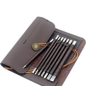 May include: A set of 10 carving tools with brown leather handles and a brown leather carrying case. The tools have different shaped blades and are used for carving wood.