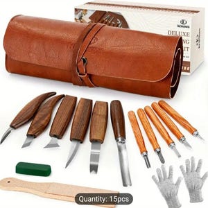Pu&ograve; includere: Un set di 15 strumenti per intagliare il legno con un astuccio arrotolabile in pelle marrone. Gli strumenti hanno manici in legno e lame in metallo. Il set include anche una pietra per affilare verde, un blocco di levigatura in legno e un paio di guanti da lavoro grigi. L'astuccio ha una cinghia in pelle marrone con una fibbia in metallo. Il testo "Quantity: 15pcs" &egrave; stampato nella parte inferiore dell'immagine.