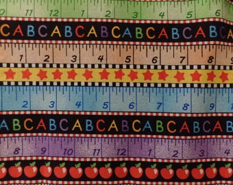 May include: A colorful fabric with a repeating pattern of rulers, stars, and letters. The rulers are marked with numbers from 1 to 12. The stars are red and yellow. The letters are in a black, white, red, blue, and green color scheme. The fabric is perfect for quilting, sewing, or crafting.