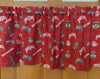 May include: Red valance featuring a repeating pattern of Ohio State University logos, the word "Buckeyes", and the mascot Brutus Buckeye. The valance is designed to hang above a window.