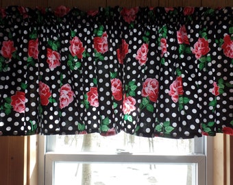 May include: Black and white valance with a polka dot pattern and red roses. The valance is made of fabric and has a ruffled edge.