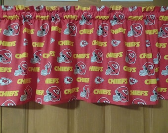 May include: Red and yellow fabric valance with a repeated pattern of a football helmet and the word "Chiefs".