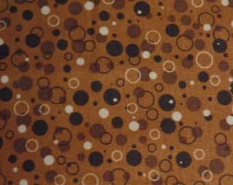 May include: Brown fabric with a repeating pattern of white, brown, and black circles of varying sizes.